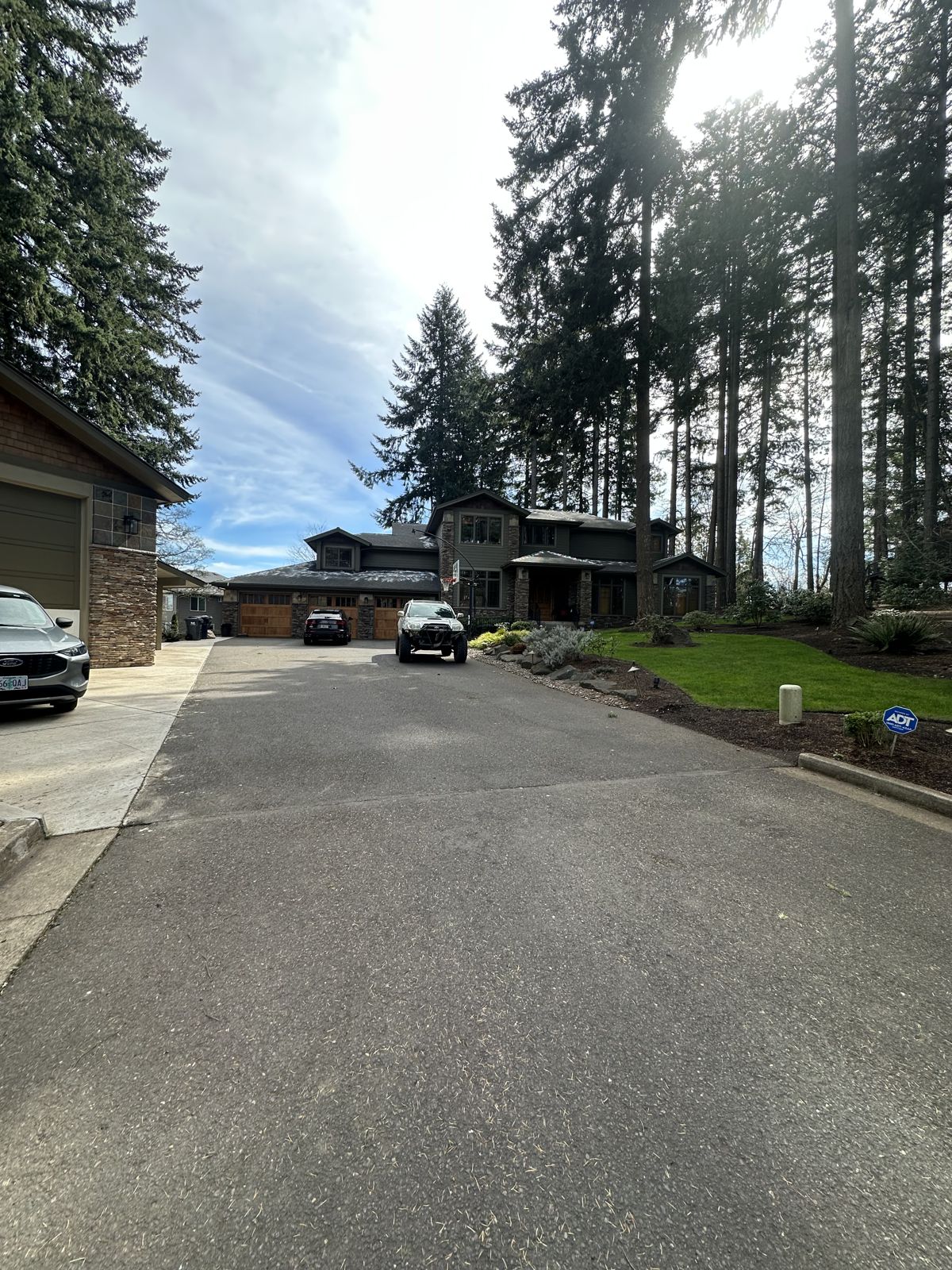 Driveway and home exterior after a completed gutter cleaning job